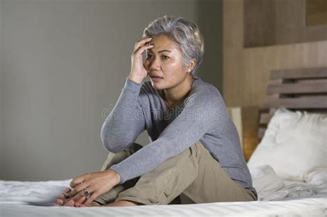 Dramatic Lifestyle Home Portrait Of Attractive Sad And Depressed Middle Aged Woman With Grey