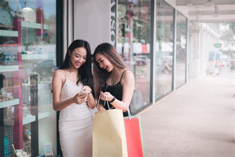 Two Beautiful Woman Using Smartphone At Shopping Mall Stock Image
