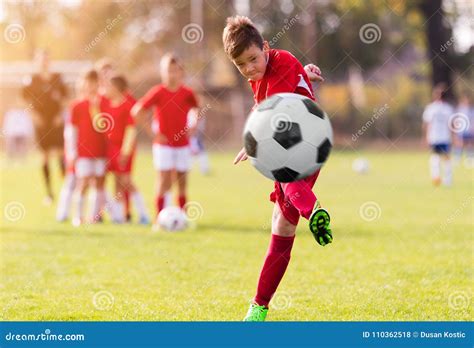 Boy Kicking Football On The Sports Field Stock Photo Image Of Shoot