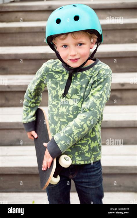 Boy With Skateboard Standing Outdoors Stock Photo Alamy