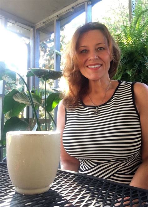 A Woman Sitting At A Table With A Glass Of Milk In Front Of Her