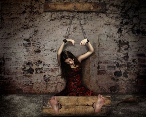 Woman Chained To The Wall And In Stocks Chained To The Wall