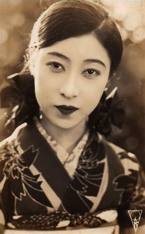 An Old Black And White Photo Of A Woman In Traditional Japanese Dress Holding A Bowl