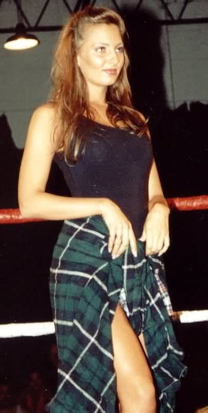 A Woman Standing In Front Of A Boxing Ring Wearing A Black Tank Top And