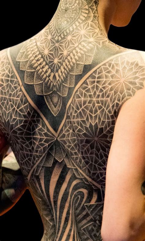 The Back Of A Womans Body With Tattoos On Her Upper And Lower Half