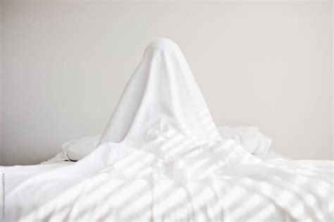 Boy Hiding Under A Sheet On A Bed Del Colaborador De Stocksy Kelly