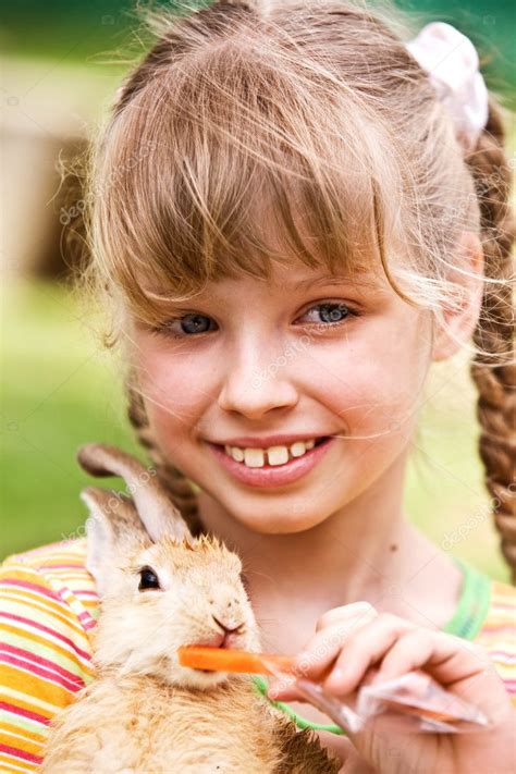 Happy Girl Feed Rabbit With Carrot — Stock Photo © Poznyakov 1049334