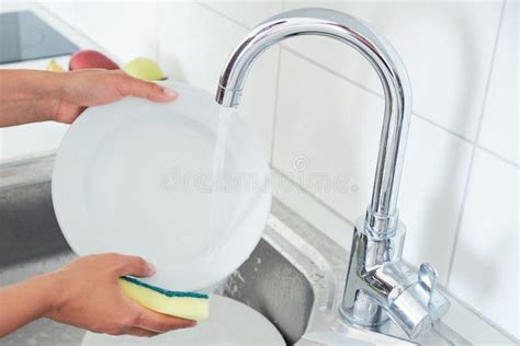 Cropped Image Of Attractive Young Woman Is Washing Dishes While Doing