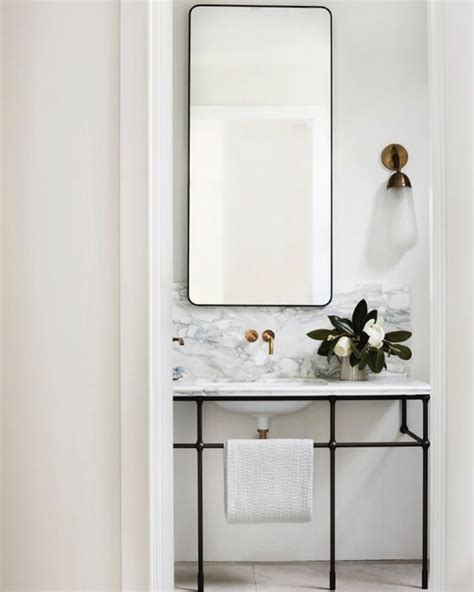 Elegant Powder Room That Boasts A Rounded Edge Rectangle Mirror