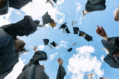 Grad Recent Graduates Toss Their Caps In The Air By Stocksy