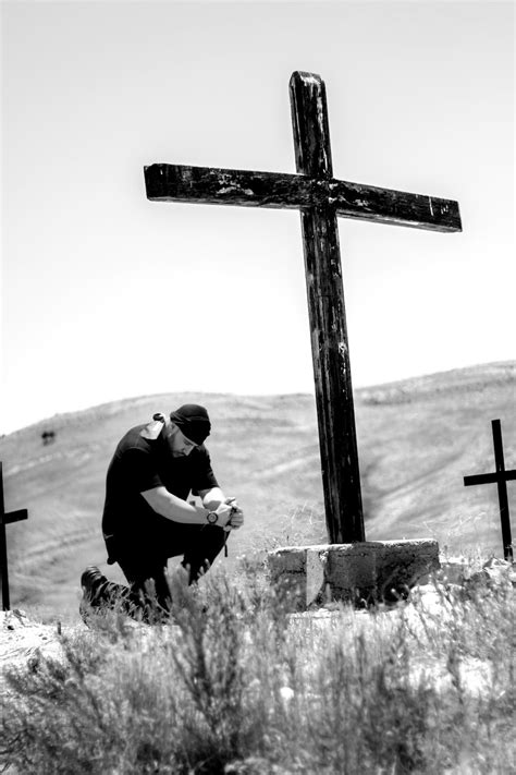Man Kneeling In Front Of Wooden Cross Photo Free Black And White