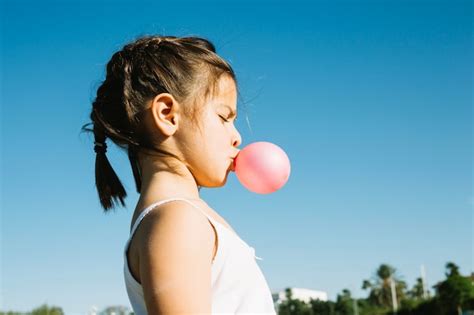 Cute Girl Blowing Bubble Gum Free Photo