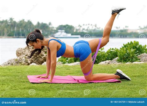 Fitness Woman Doing Kickback Exercise For Glute With Resistance Band Outdoors Athletic Girl