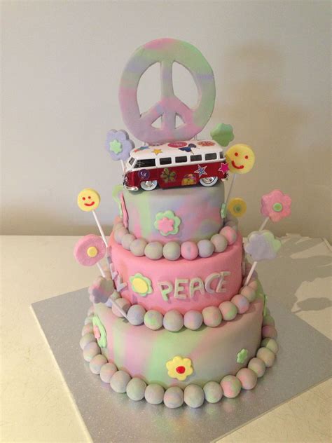 A Peace Sign Cake With Pink And Green Frosting On The Top Is Decorated With Flowers