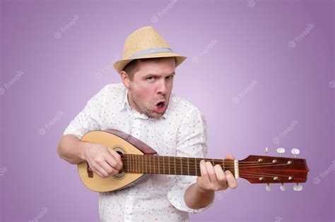 Hombre Con Sombrero De Verano Tocando La Guitarra Y Cantando Canciones Foto Premium