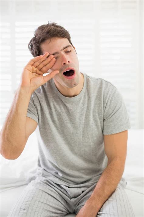 Sleepy Man Yawning As He Rubs His Eye In Bed Stock Image Image Of