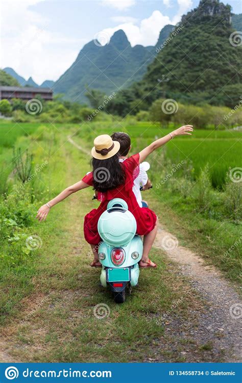 Couple Riding Motorbike Around Rice Fields Of Yangshuo China Stock