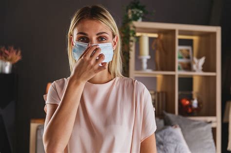 Woman Demonstrating How To Wear A Disposable Mask Stock Photo