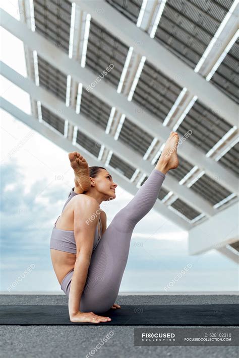 Full Body Side View Of Slim Female Performing Yoga Pose While Sitting