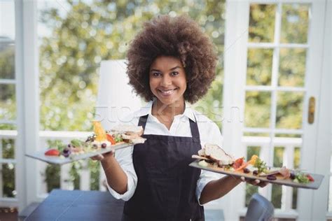 Portrait Of Smiling Waitress Holding Food Tray Stock Photo C