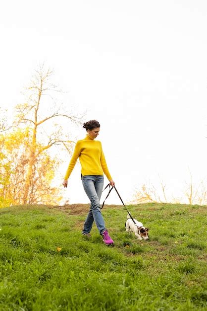 Tiro Completo Mujer Paseando A Su Perro En El Parque Foto Gratis