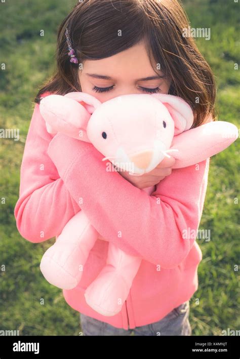 A 10 Year Old Girl Hugging And Playing With Her Favorite Stuffed Animal