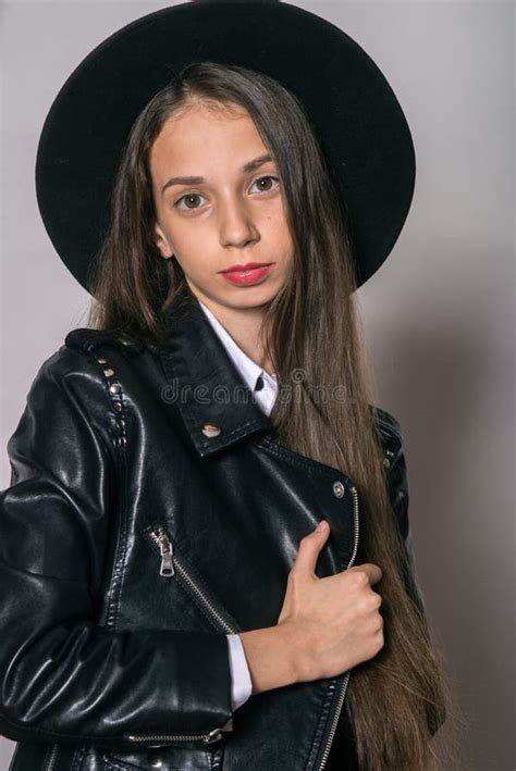 A Teenage Girl In A Trendy Leather Jacket And An Even Hat On A White