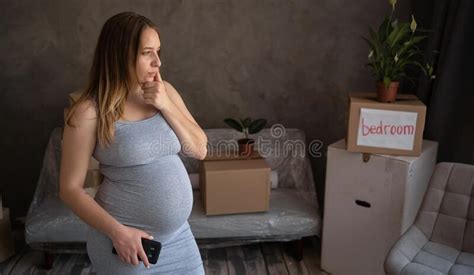 Thoughtful Pregnant Woman Standing Among Boxes Single Expectant Mother