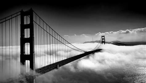 Black And White Image Of The Golden Gate Bridge In San Francisco Rising