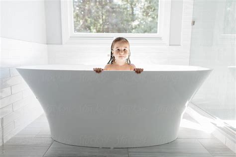 A Beautiful Young Girl Peeking Out From A Large Bathtub Del Colaborador De Stocksy Jakob