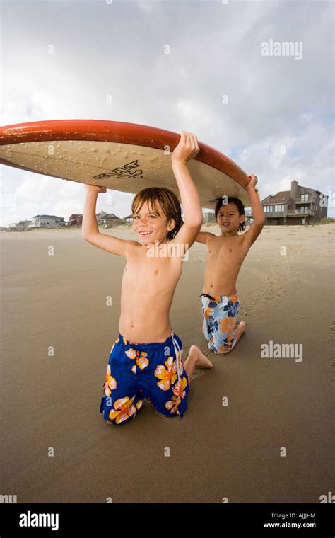 Two Boys Holding Surfboard On The Beach Sandbridge Virginia Beach
