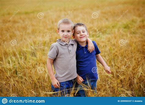 Portrait Of Two Boys In T Shirts And Shorts In A Wheat Field Fun