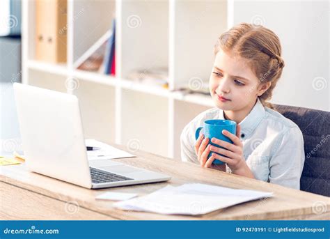 Girl Pretending To Be Businesswoman And Working With Laptop In Office