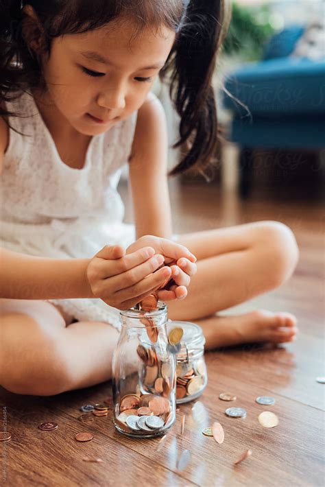 Adorable Girl Putting Coins In Jar By Stocksy Contributor Maahoo