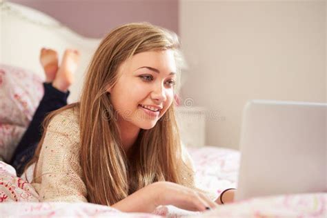 Teenage Girl Lying On Bed Using Laptop Wearing Headphones Stock Image Image Of Smiling Year