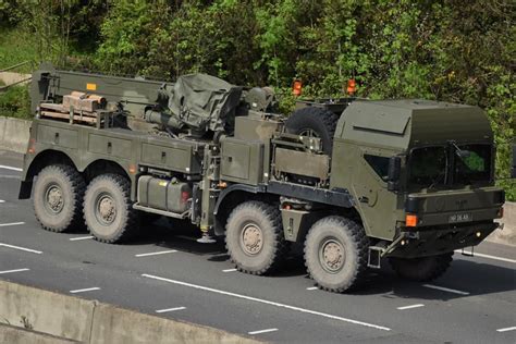 An Army Truck Is Driving Down The Road