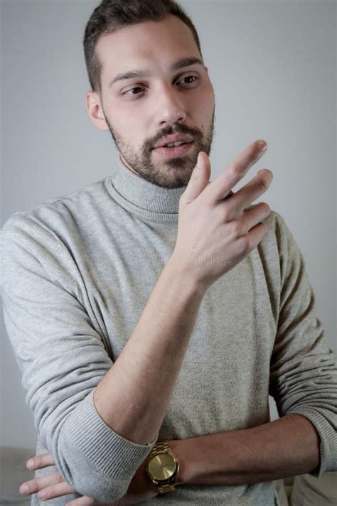 Young Man With A Short Beard Speaks Gesturing With His Hands To Explain
