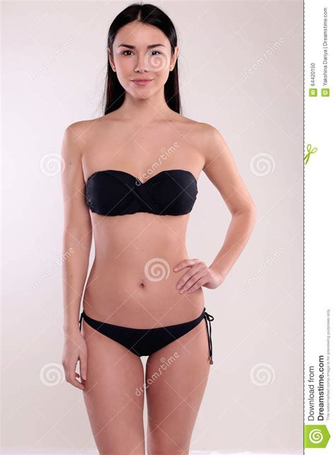 La Bella Donna Con L Ente Perfetto Con Capelli Diritti Scuri Porta Il Bikini Nero Fotografia