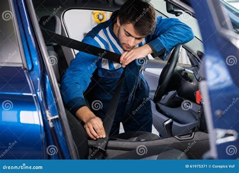 Mechanic Examining Under Hood Of Car With Torch Royalty Free Stock
