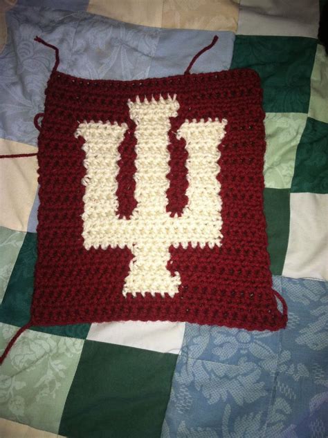 A Red And White Crocheted Blanket With The Letter U On Its Side