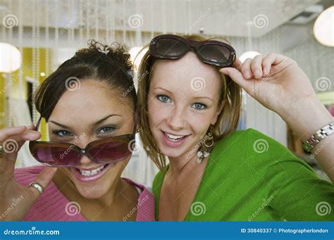 two girls trying on sunglasses in boutique portrait close up stock image image of fashion