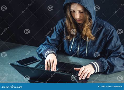 Girl Hacker In A Hood Typing Program Code While Committing A Cybercrime