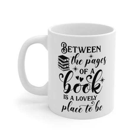 a white coffee mug that says between the pages of a book is a lovely place to be