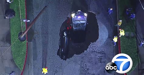 Storm Sinkhole Swallows Two Cars With Drivers Still Inside In