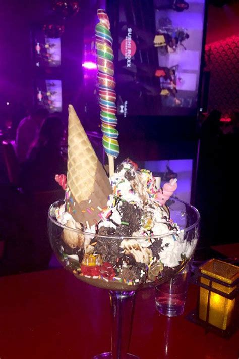 An Ice Cream Sundae In A Wine Glass On A Table With A Lit Candle