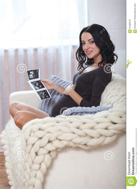 Happy Beautiful Pregnant Woman Relaxing On Sofa With Echo In Hands Stock Image Image Of Belly