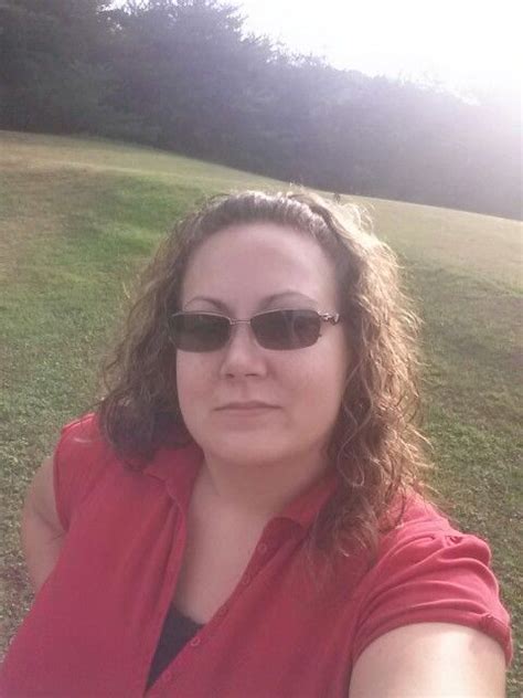 a woman wearing sunglasses taking a selfie in the park