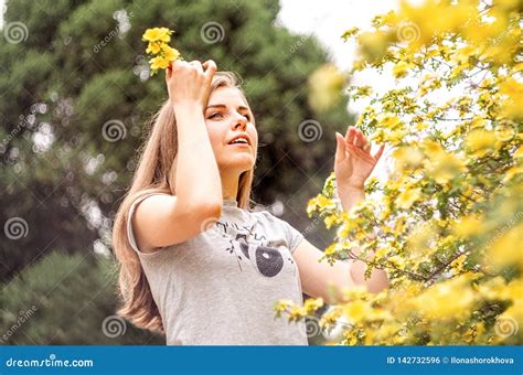 Happy Young Caucasian Woman Enjoying Flowers Blossom In Spring Stock