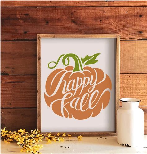 An Orange Pumpkin With The Words Happy Fall On It Next To A White Vase