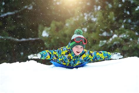 Boy Sledding In A Snowy Forest Outdoor Winter Fun For Christmas
